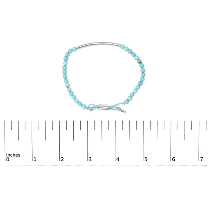Turquoise bead bracelet with silver accents, clasp, and a ruler showing size in inches.
