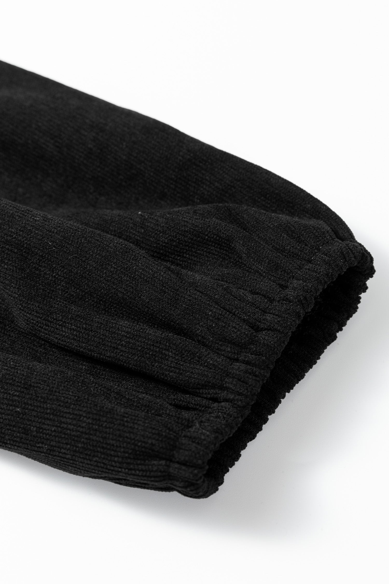 Black ribbed fabric sleeve with elastic cuff on a white background.