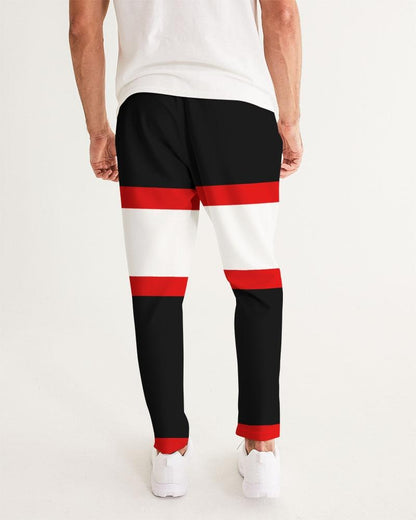 Man wearing black pants with red and white horizontal stripes, white top, and white shoes.