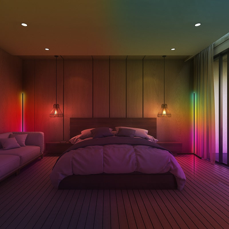 Modern bedroom with ambient rainbow lighting, wood panel walls, a bed center, and cozy seating.