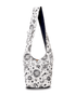 White hobo bag with black celestial designs of suns, moons, and stars.