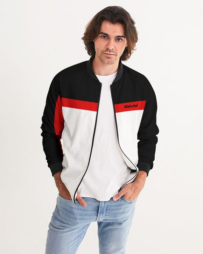 Man in a black, white, and red jacket with blue jeans against a white background.