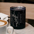 Black tumbler with map design and "Charlotte" text, on marble table near a cappuccino.
