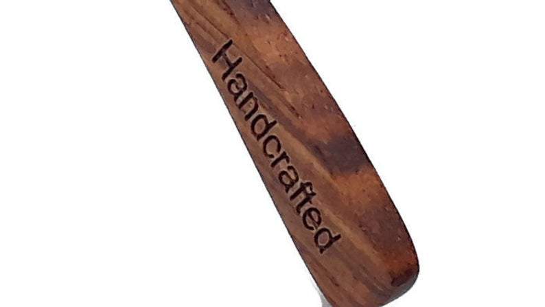 Wooden handle with "Handcrafted" engraved, featuring a rich, brown grain.
