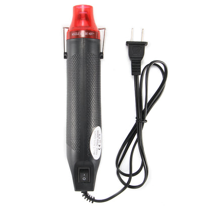 Black heat gun with a red nozzle, textured grip, power switch, and attached black power cord.