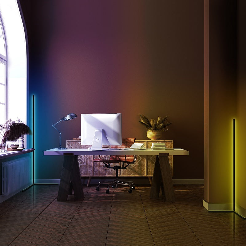 Modern office with a wooden desk, large monitor, gradient wall lighting, and wooden floor.