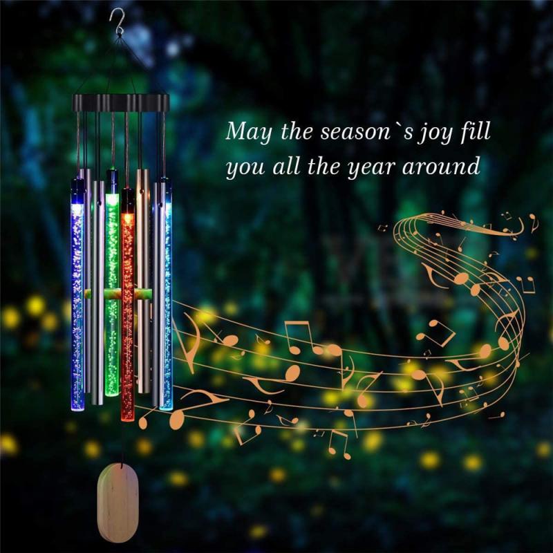 Colorful glowing wind chimes with musical notes, set against a dark, blurred background.