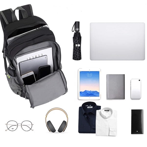 Black backpack with open compartments holding gadgets, surrounded by laptop, clothes, and accessories.