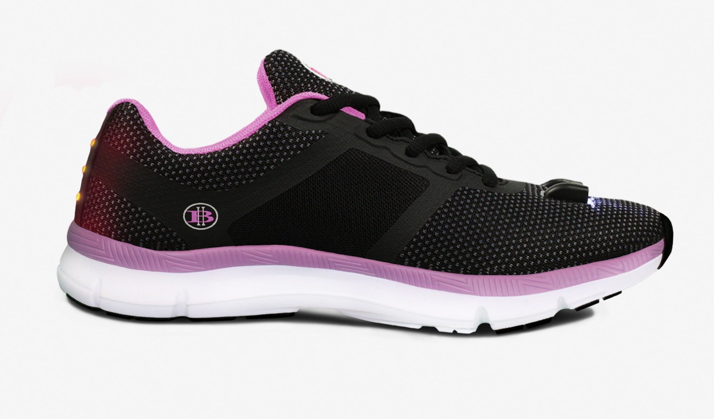 Black athletic shoe with a pink sole and trim, mesh texture, and white midsole on a white background.