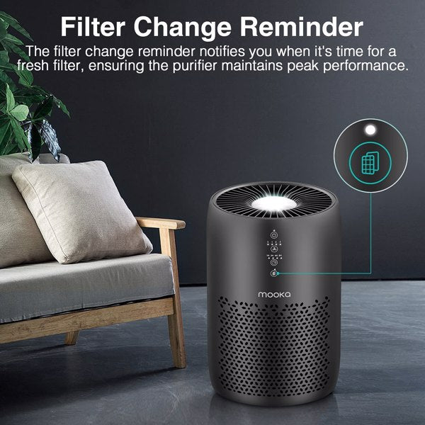 Black air purifier in a living room with a grey sofa, displaying a filter change reminder.