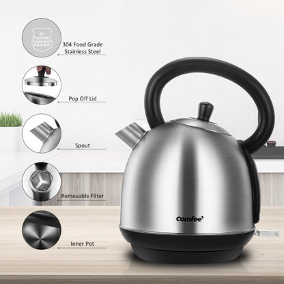 Stainless steel kettle with black handle, spout, and pop-off lid on a wooden surface.