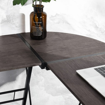 Dark wood corner desk with a laptop and brown vase with green leaves on a white background.