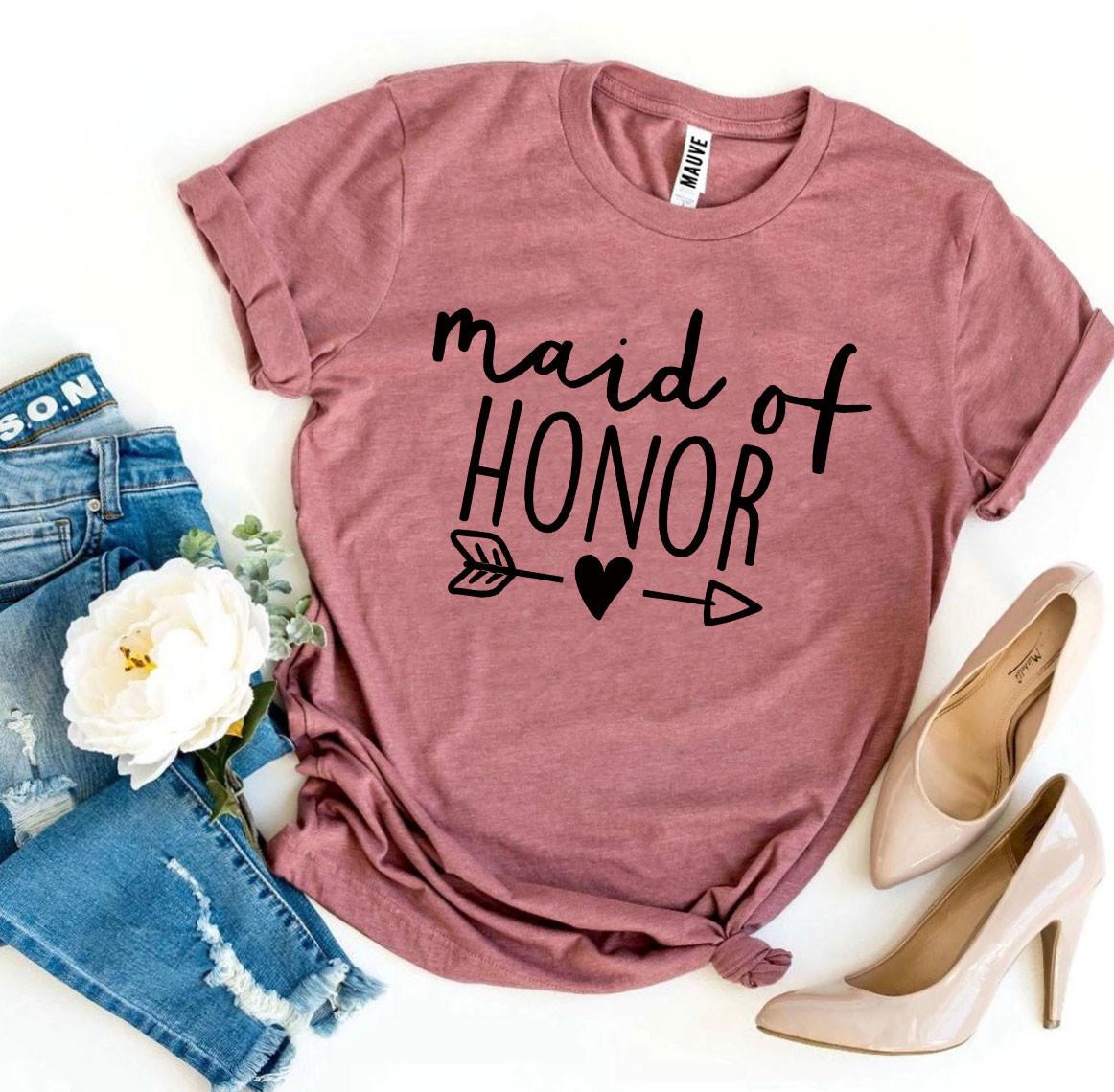 Pink "Maid of Honor" shirt with arrow and heart, paired with jeans, white flower, and heels.
