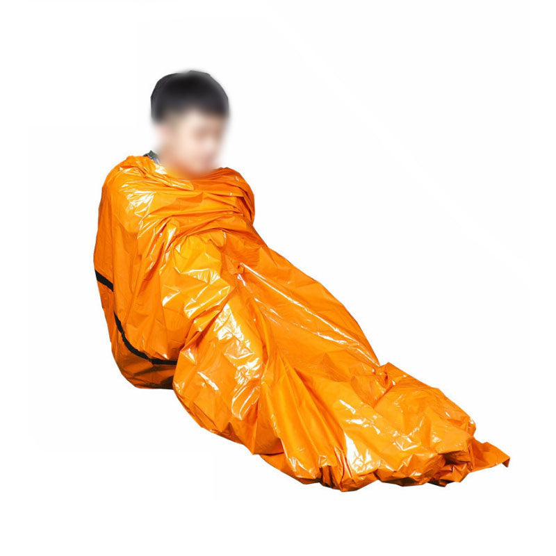 Person wrapped in a crinkled, shiny orange emergency blanket on a white background.