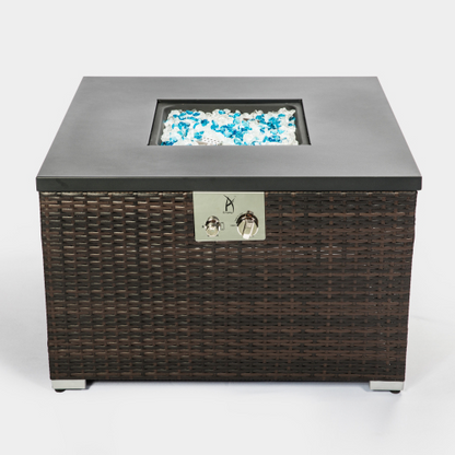 Square wicker fire pit table with glass beads, black top, and metal controls.