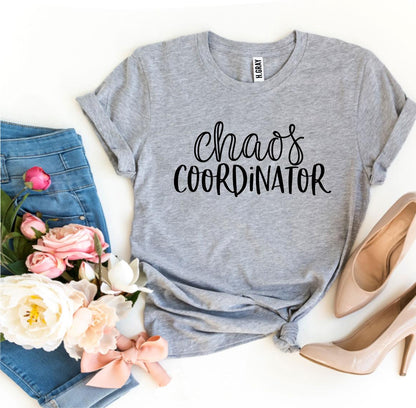 Gray tee with "Chaos Coordinator" text, surrounded by jeans, pink flowers, and beige heels.