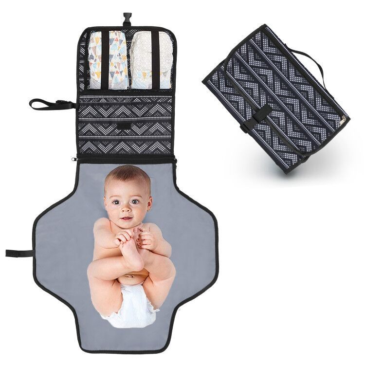 Baby on gray changing pad with zigzag patterned diaper holder, shown open and folded.