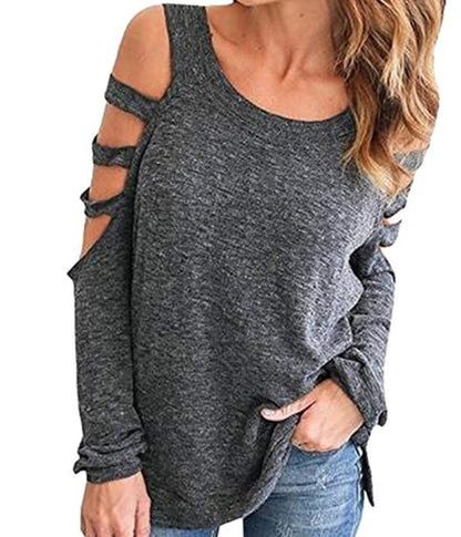 Gray sweater with cold shoulder cutouts and multiple arm straps, paired with blue jeans.