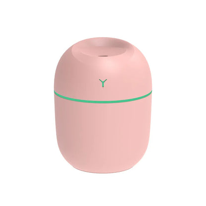 Pink cylindrical humidifier with a teal stripe and a small opening on top.