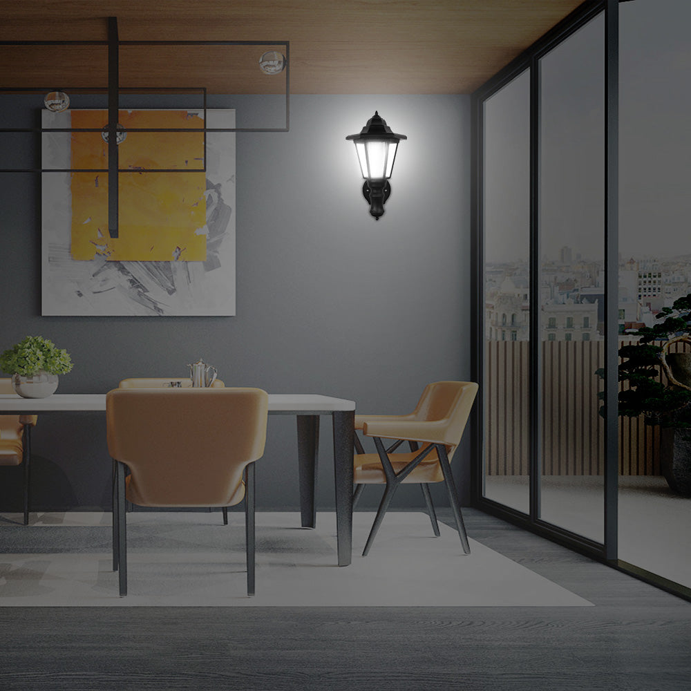 Modern dining area with beige chairs, a wall lamp, abstract art, and large glass windows.