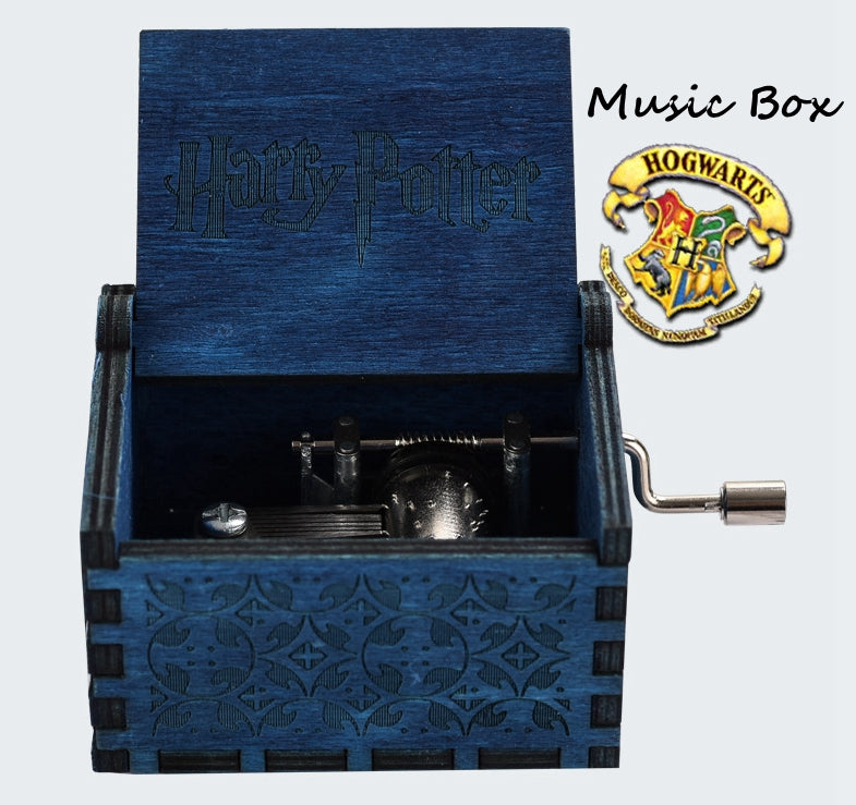 Blue Harry Potter-themed music box with decorative patterns and a hand crank. Hogwarts emblem visible.