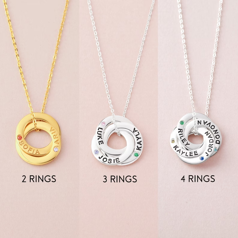 Three necklaces with customized rings; gold with two rings, silver with three and four rings.