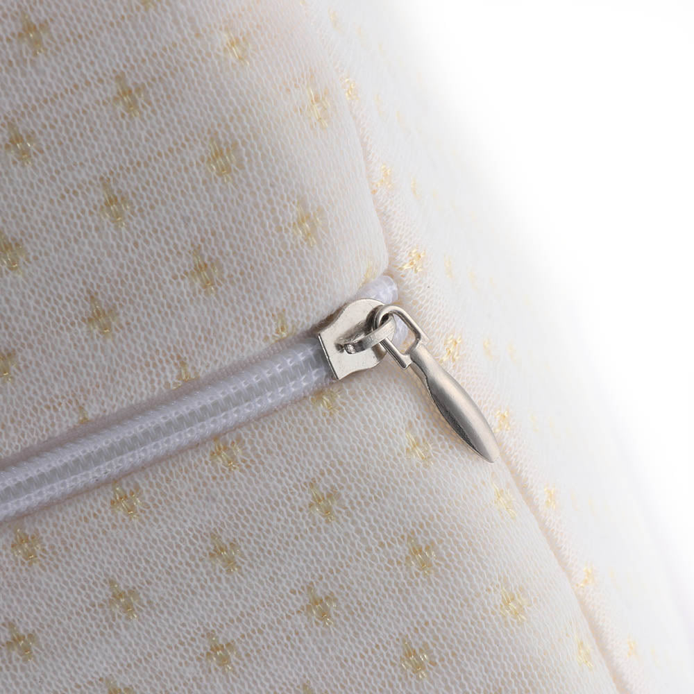 Close-up of a silver zipper on white fabric with small yellow crosses.