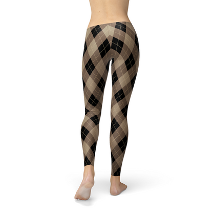 Back view of plaid leggings in brown and black pattern on a person standing barefoot.