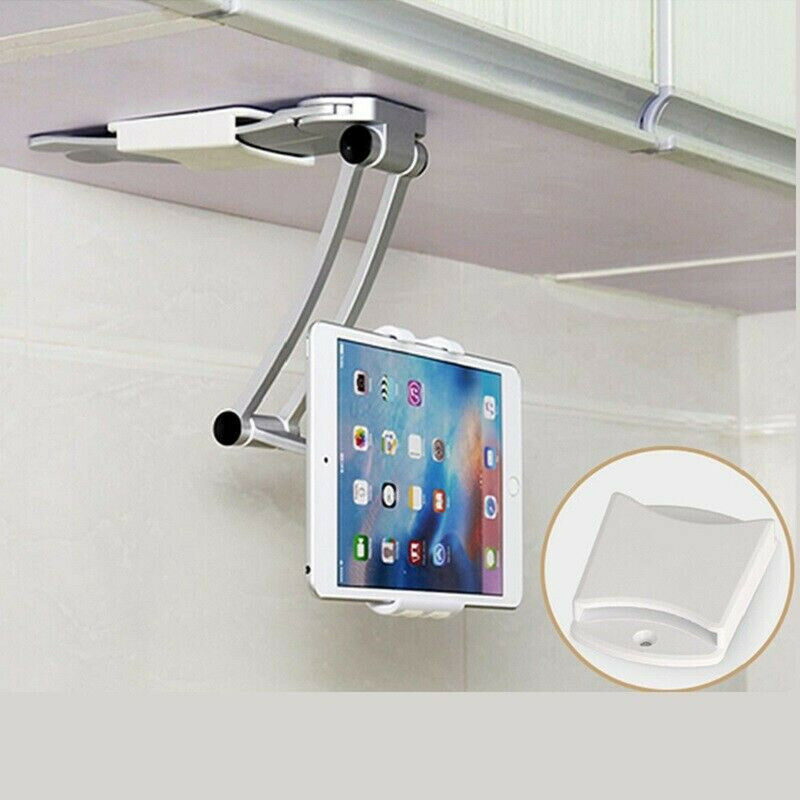 Tablet in a white holder mounted under a cabinet, with a silver arm and beige wall background.