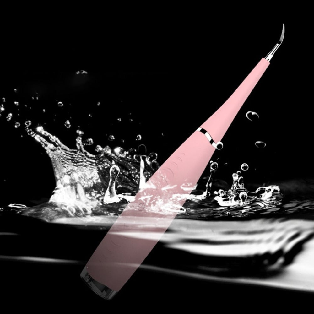 Pink dental tool splashing in water against a black background.