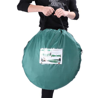 Person holding a large, round, green bag with handles and a label on the front.