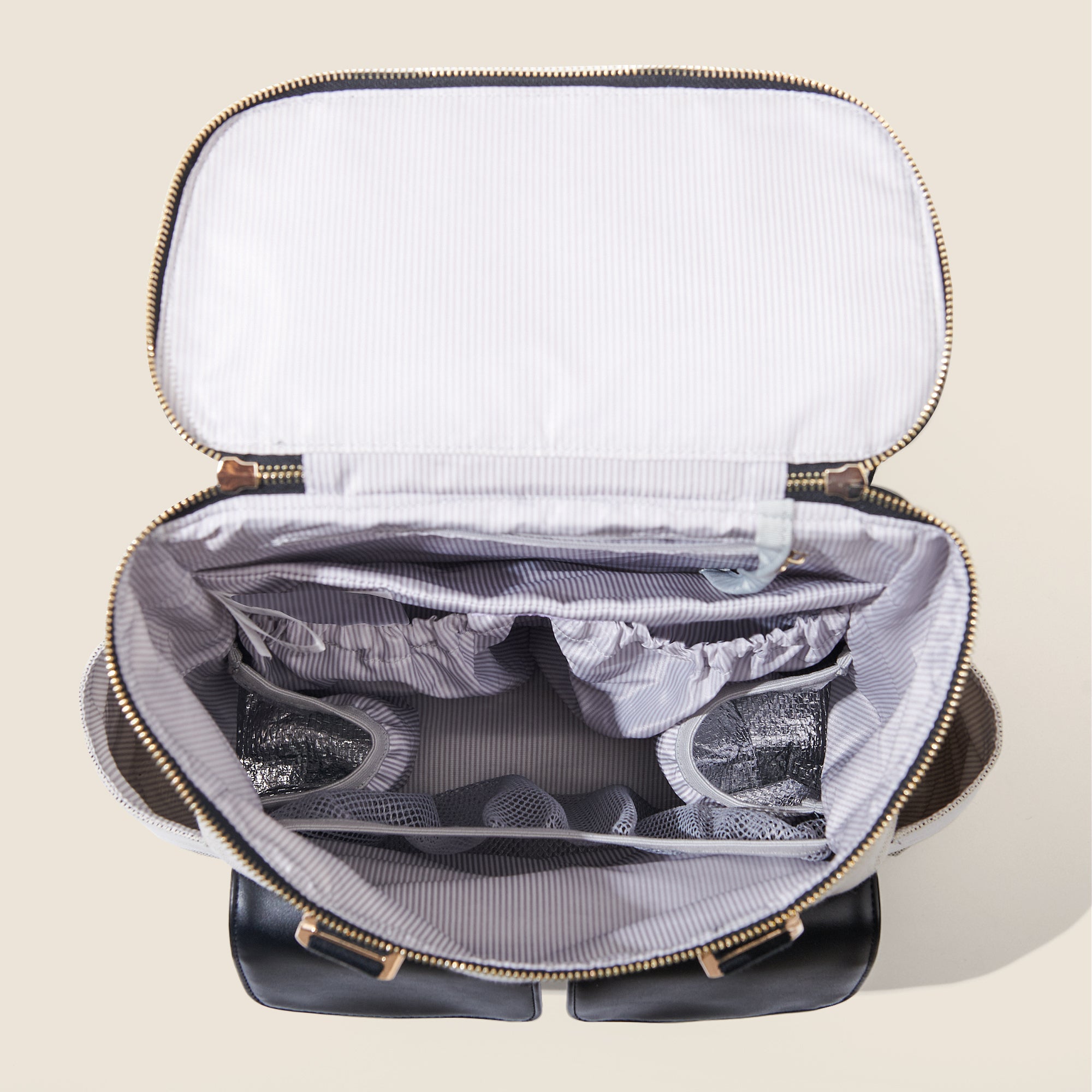 Open black backpack with striped inner lining, multiple compartments, and zipper visible.