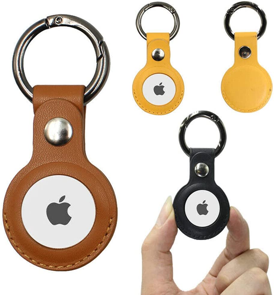 Leather keychain holders in brown, yellow, and black, each with a metal ring and circular insert.