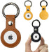 Leather keychain holders in brown, yellow, and black, each with a metal ring and circular insert.
