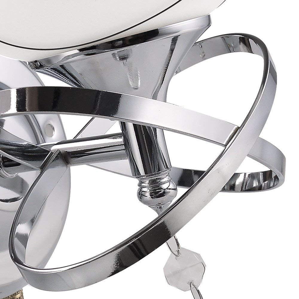 Chrome metal rings interconnected around a white circular object, with a reflective surface.