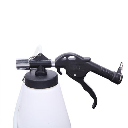 Black spray nozzle attached to a white container, featuring a trigger handle and metal tip.