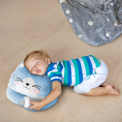 Toddler sleeping on a blue cat pillow, wearing a striped shirt, clutching a baby bottle.