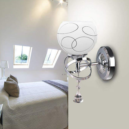 Modern wall sconce with chrome base and white glass shade in bright, minimalist bedroom.