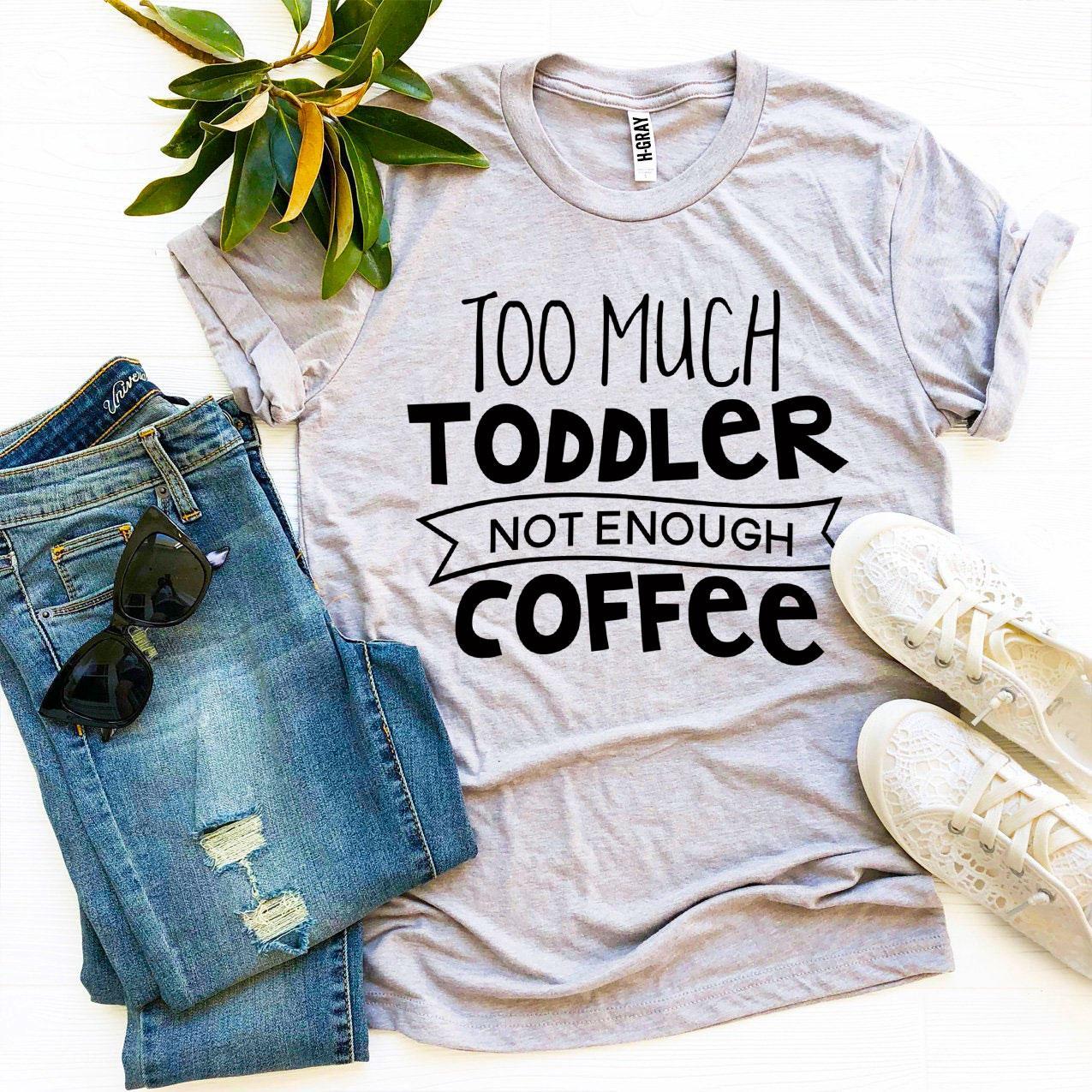 Gray t-shirt with text, blue jeans, sunglasses, white sneakers, and a small green plant.