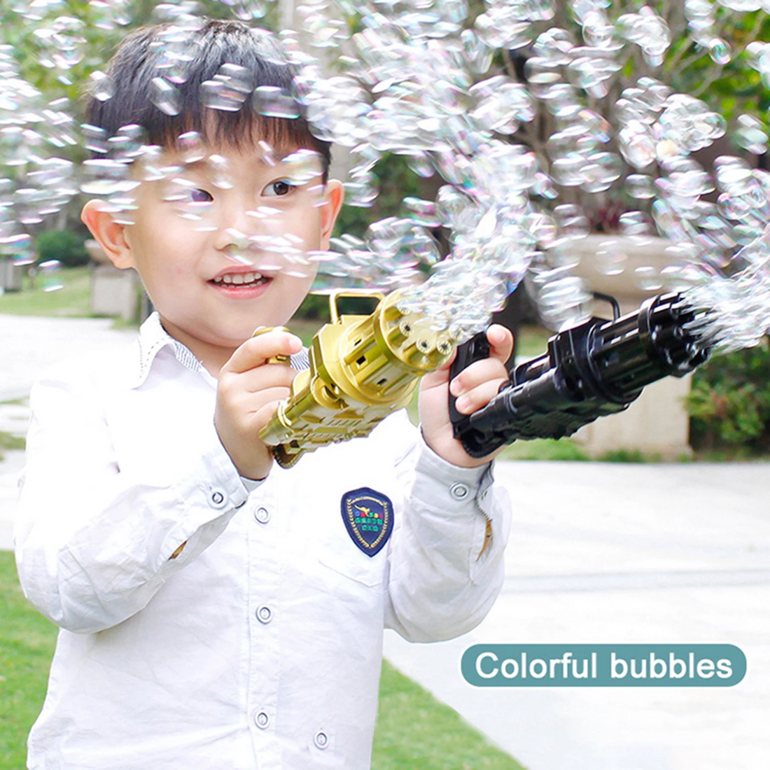 Child in a white shirt playing with bubble guns, emitting numerous colorful bubbles outdoors.