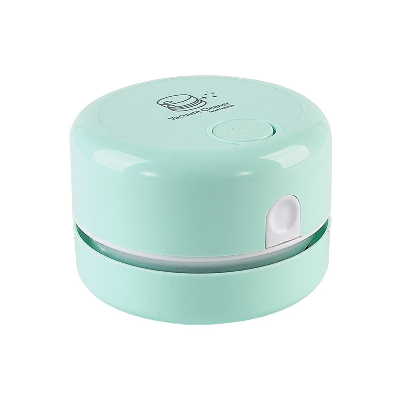 Mint green mini vacuum cleaner with a rounded design and a small button on top.