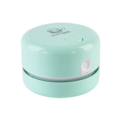 Mint green mini vacuum cleaner with a rounded design and a small button on top.