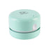 Mint green mini vacuum cleaner with a rounded design and a small button on top.