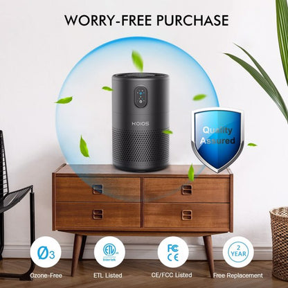 Black air purifier on wooden dresser, green leaves around, blue shield with "Quality Assured."