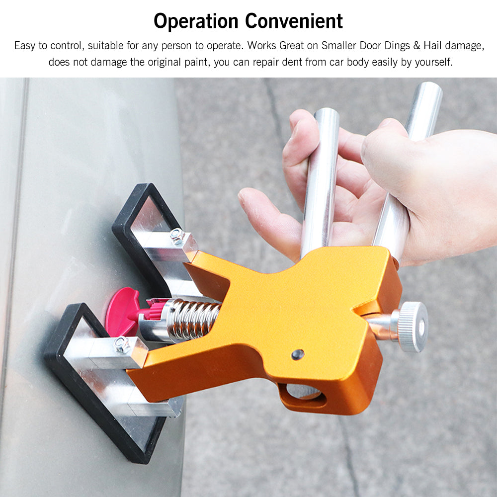 Hand using an orange dent puller with silver handles on a car surface.