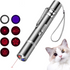 Silver laser pointer with multiple red light patterns and a cat looking up curiously.
