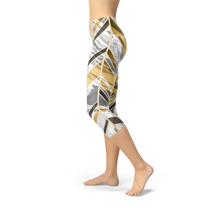 Person wearing colorful leggings with abstract brown, gray, and yellow patterns, standing barefoot.