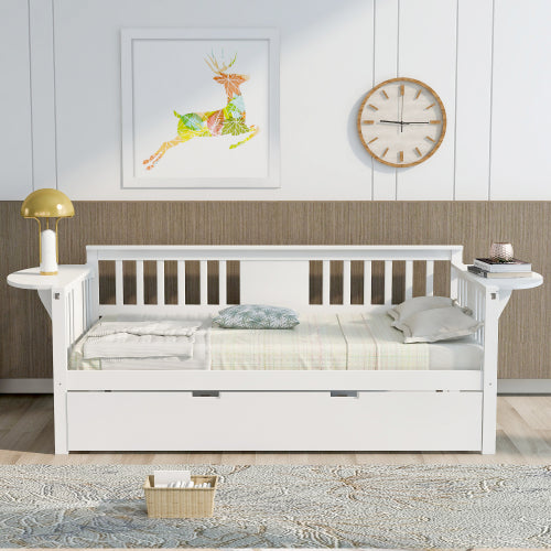 White daybed with slatted back, yellow lamp, clock on wall, deer art, and wicker basket on rug.