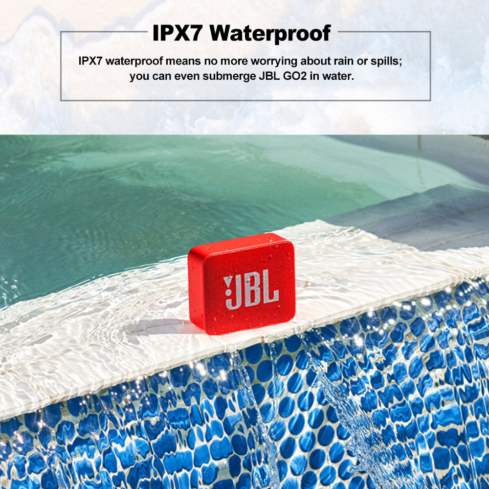 Red JBL speaker on pool edge with blue tiles, demonstrating water resistance.