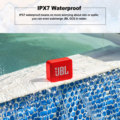 Red JBL speaker on pool edge with blue tiles, demonstrating water resistance.